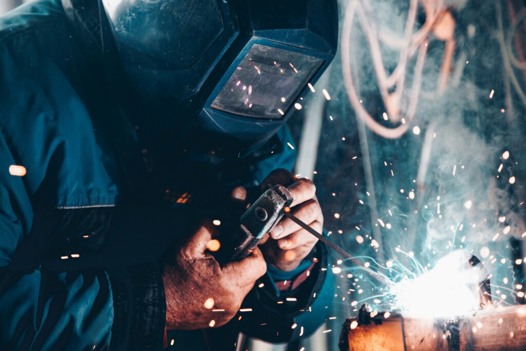 welder wearing a protective mask as sparks fly