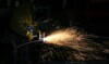 masked welder at work with sparks flying