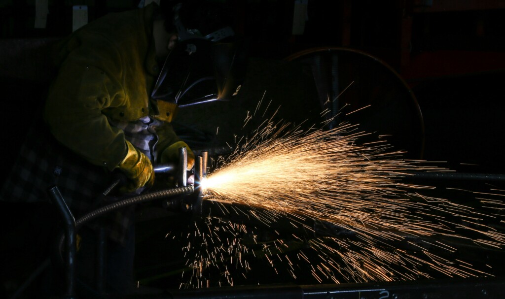 masked welder at work with sparks flying
