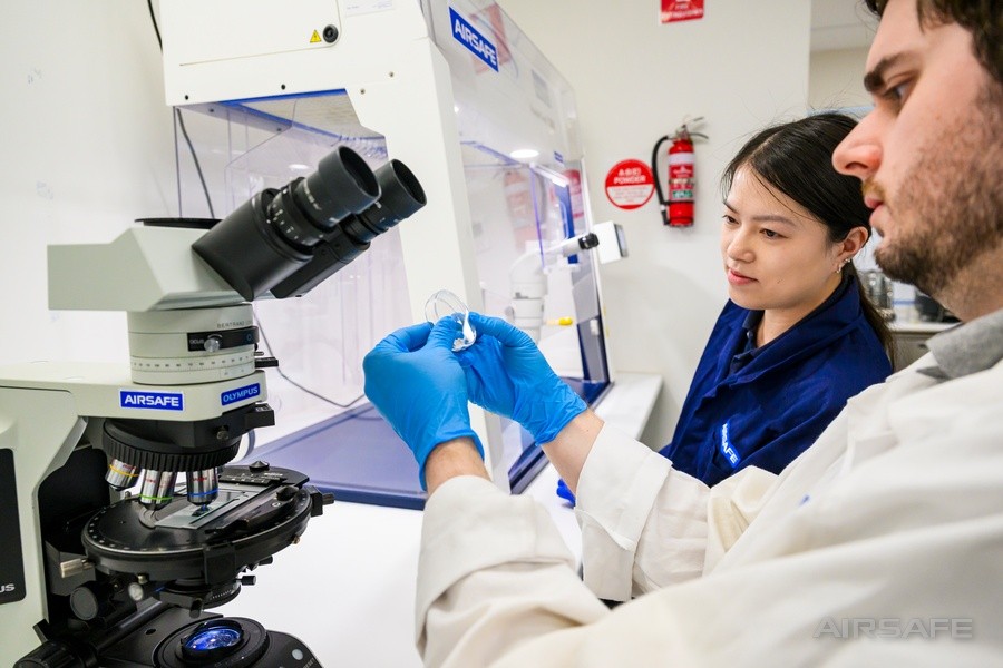 Two Airsafe analysts examining an asbestos sample at the fume cupboard