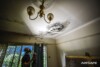 An Airsafe consultant inspecting mould growth on a ceiling around a light fitting