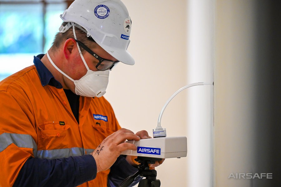 Airsafe consultant programming a tripod-mounted air sampling pump during a mould investigation